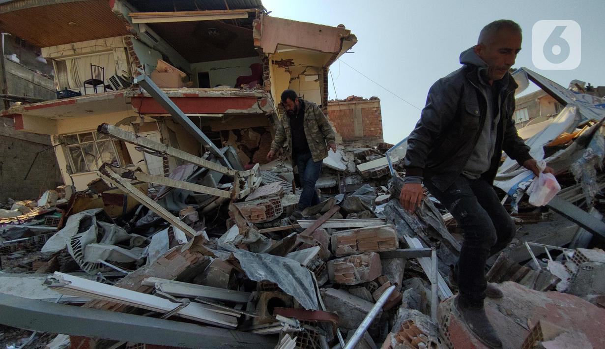 Warga melintasi reruntuhan bangunan di kota Antakya, Provinsi Hatay, Turki, Sabtu (18/2/2023). Kondisi bangunan di kota tua Antakya, Provinsi Hatay, Turki hancur akibat gempa berkekuatan magnitudo 7,8 yang menguncang Turki dan Suriah pada 6 Februari dini hari lalu. (Liputan6.com/Andry Haryanto)