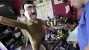 Pekerja melihat wajah raja narkoba Joaquin "El Chapo" Guzman melalui laptop saat membuat bonekanya di Reynosa, Meksiko (21/7/2015). Guzman melarikan diri dari penjara melalui terowongan yang ia buat pada bulan lalu. (REUTERS/Daniel Becerril)