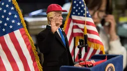 Boneka Presiden AS Donald Trump saat pidato di toko mainan, Hong Kong (3/2). Pembuat boneka di Hong Kong yang sering menciptakan boneka pemimpin dunia yang kontroversial telah membuat boneka Donald Trump. (AFP Photo/Anthony Wallace)