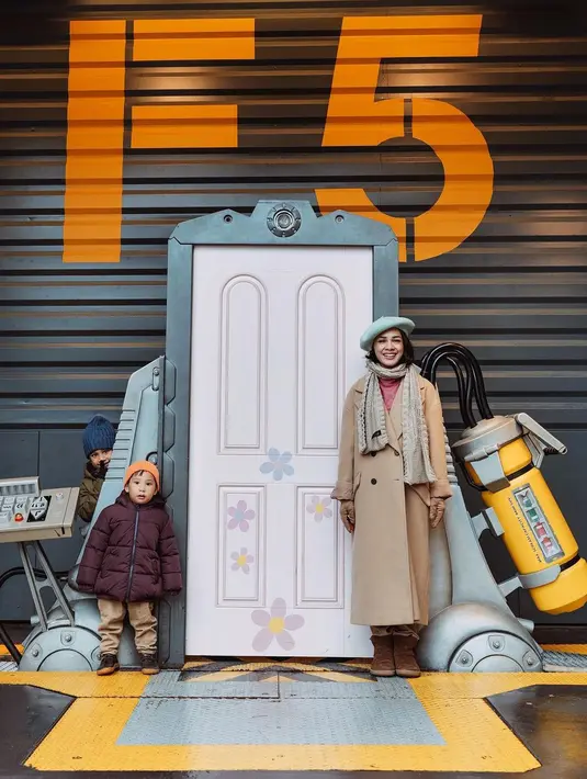 Main di Disneyland, Andien pilih kenakan long coat cokelat dan inner pink [instagram/andienaisyah]