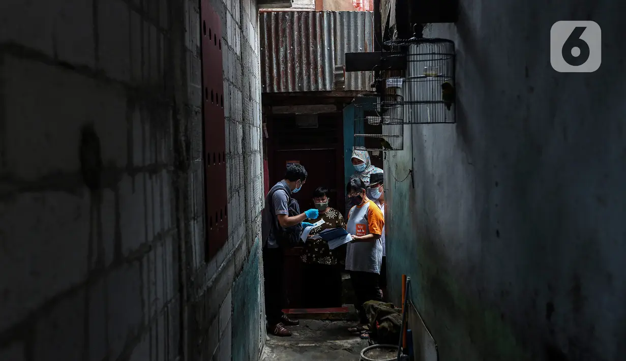 Petugas menyerahkan bantuan sosial tunai (BST) kepada warga penerima manfaat di RW 05 Kelurahan Kenari, Senen, Jakarta, Rabu (6/1/2021). Pencairan BST untuk empat bulan kedepan sebesar Rp300 ribu per Keluarga Penerima Manfaat (KPM) diberikan langsung kepada warga. (Liputan6.com/Johan Tallo)
