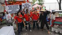 Kopral Bagyo menggandeng komuitas pemuda Tionghoa dan penarik becak melakukan aksi tolak isu SARA dengan menggelar pemainan adu sotohkan dan gendong di Solo, Rabu (14/2).(Liputan6.com/Fajar Abrori)