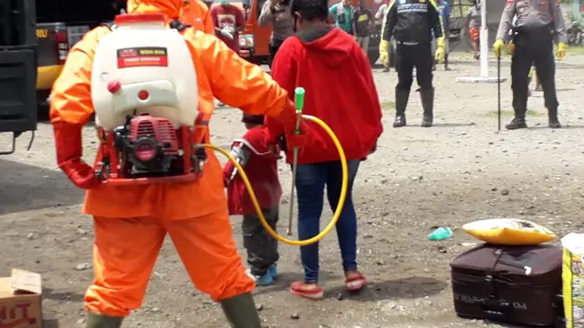 Ratusan penumpang KM Lambelu didisinfeksi sebelum memasuki gedung karantina, di Kabupaten Sikka, NTT. (Foto: Liputan6.com/Dionisius Wilibardus)
