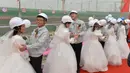 Sejumlah pekerja melaksanakan upacara pernikahan di tempat proyek mereka bekerja di sebuah bandara yang sedang dalam proses pembuatan, Beijing, Senin (12/12). Bandara baru ini dijadwalkan akan selesai pada 2019. (AFP PHOTO)