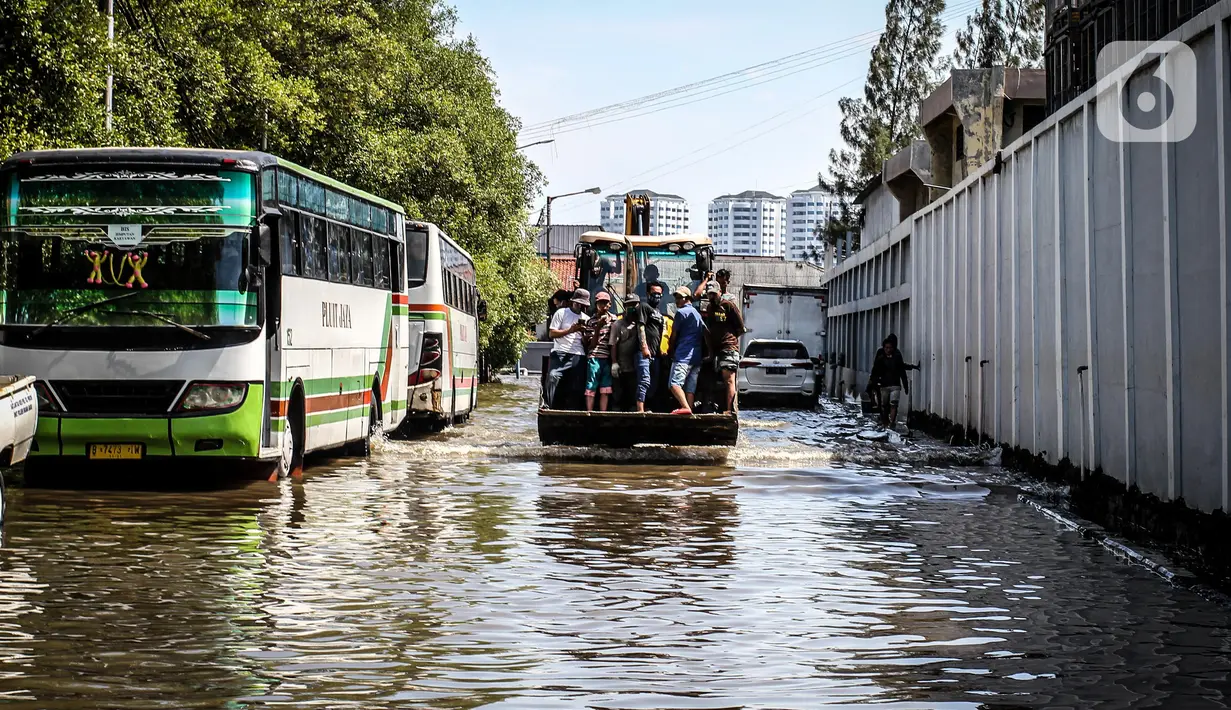 Kendaraan bermotor melintasi jalan yang tergenang air rob (banjir pasang air laut) di Kawasan Pasar Ikan Muara Baru, Jakarta, Kamis (4/6/2020). Banjir rob di Pelabuhan Muara Baru tersebut terjadi akibat cuaca ekstrem serta pasangnya air laut. (Liputan6.com/Faizal Fanani)