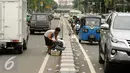 Pemulung memunguti sisa kemasan makanan dan minuman di Jalan Medan Merdeka Timur usai massa ormas melakukan unjuk rasa di Bareskrim Polri, Gedung KKP Jakarta, Jumat (14/10). Dalam aksinya, massa meminta Ahok ditahan. (Liputan6.com/Helmi Fithriansyah)