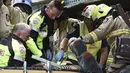 Petugas saat menyelamatkan penumpang dari dalam bus yang menabrak kolong jembatan kereta di Montague, South Melbourne, Australia (22/2). Belum diketahui penyebab tertabraknya bus yang mengangkut 19 orang ini. (REUTERS/Mal Fairclough)