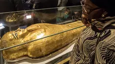 Seorang wanita memperhatikan peti mati emas mumi Nedjemankh yang dipajang di Museum Nasional Peradaban Mesir, Kairo, Selasa (1/10/2019). Nedjemankh merupakan seorang imam di zaman Ptolemeus, sekitar 2.000 tahun lalu. (Khaled DESOUKI/AFP)