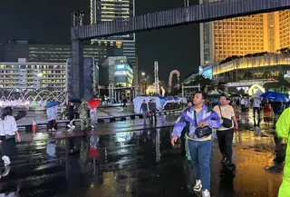 Hujan deras yang mengguyur Jakarta pada Jumat (20/3/2026) malam tidak menyurutkan antusias warga menikmati malam takbiran di Car Free Night Bundaran HI. (Liputan6.com/Delvira Hutabarat)