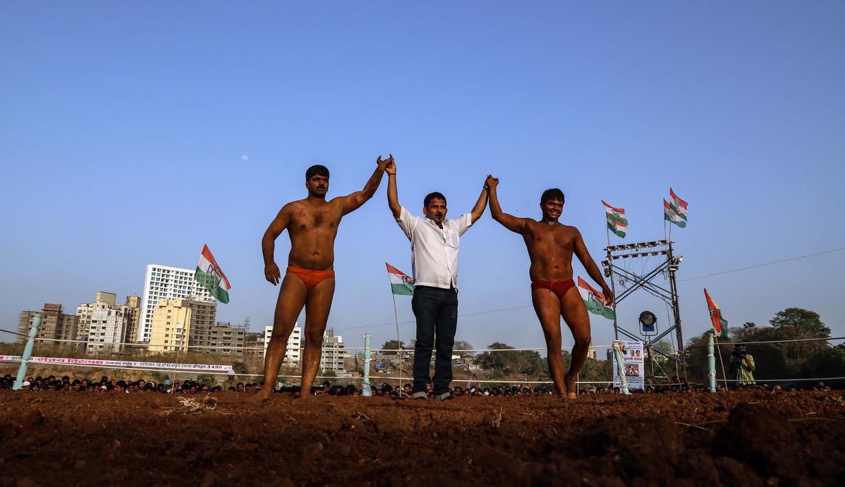 Wasit mengangkat tangan pemenang laga Indian traditional wrestling competition atau Kushti di Arena Akhara, Mumbai, India, 20 Maret 2016. Olahraga tradisional ini terus dilestarikan sebagai bagian dari budaya. (EPA/Divyakant Solanki)