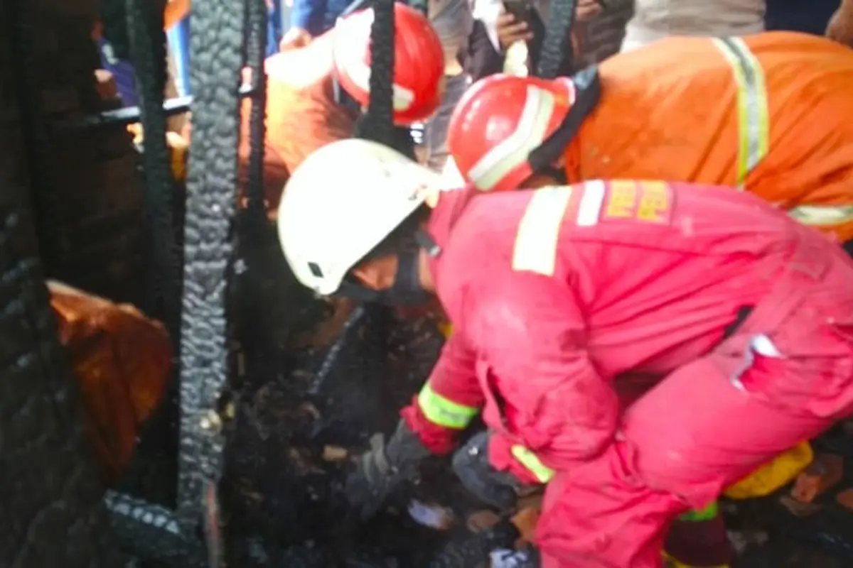 Petugas mengevakuasi jenazah bocah tewas terbakar dari lemari tempatnya bersembunyi.
