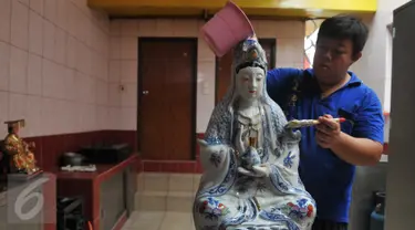 Seorang umat membersihkan patung dewa-dewi saat ritual cuci dewa di Klenteng Dharma Bhakti,Jakarta, minggu, (31/1). Pencucian sejumlah patung ini dilakukan guna menyambut tahun baru imlek China 2567. (Liputan6.com/Gempur M Surya)