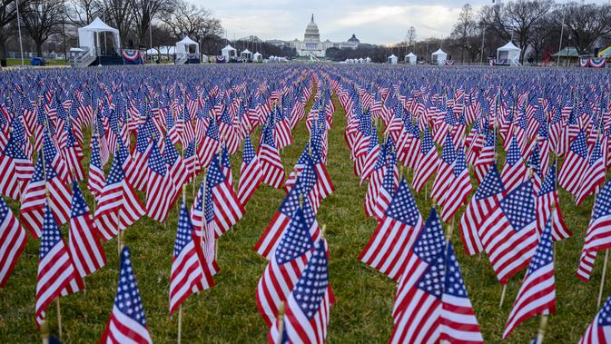 Ribuan bendera terlihat di National Mall menjelang upacara pelantikan Joe Biden sebagai presiden Amerika Serikat (AS) ke-46 di Washington, DC., Senin (18/1/2021). Tidak boleh ada kerumunan massa, dan pandemi virus corona membuat kursi-kursi tamu pelantikan harus diberi jarak. (Eric BARADAT/AFP)