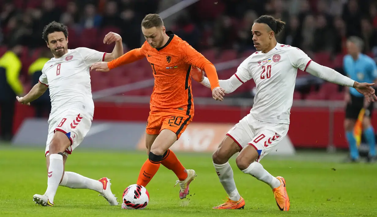 Pemain Belanda Teun Koopmeiners (tengah) berebut bola dengan pemain Denmark Thomas Delaney (kiri) dan Yussuf Poulsen pada pertandingan persahabatan di Johan Cruyff ArenA, Amsterdam, Belanda, 26 Maret 2022. Belanda menang 4-2. (AP Photo/Peter Dejong)