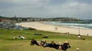 Sebelumnya, dua pelaku bersenjata, yang diyakini merupakan ayah dan anak, melepaskan tembakan saat ribuan warga Yahudi merayakan Hanukkah. Tampak dalam foto, orang-orang terlihat di Pantai Bondi, Sydney, Australia pada Senin 15 Desember 2025. (Saeed KHAN/AFP)