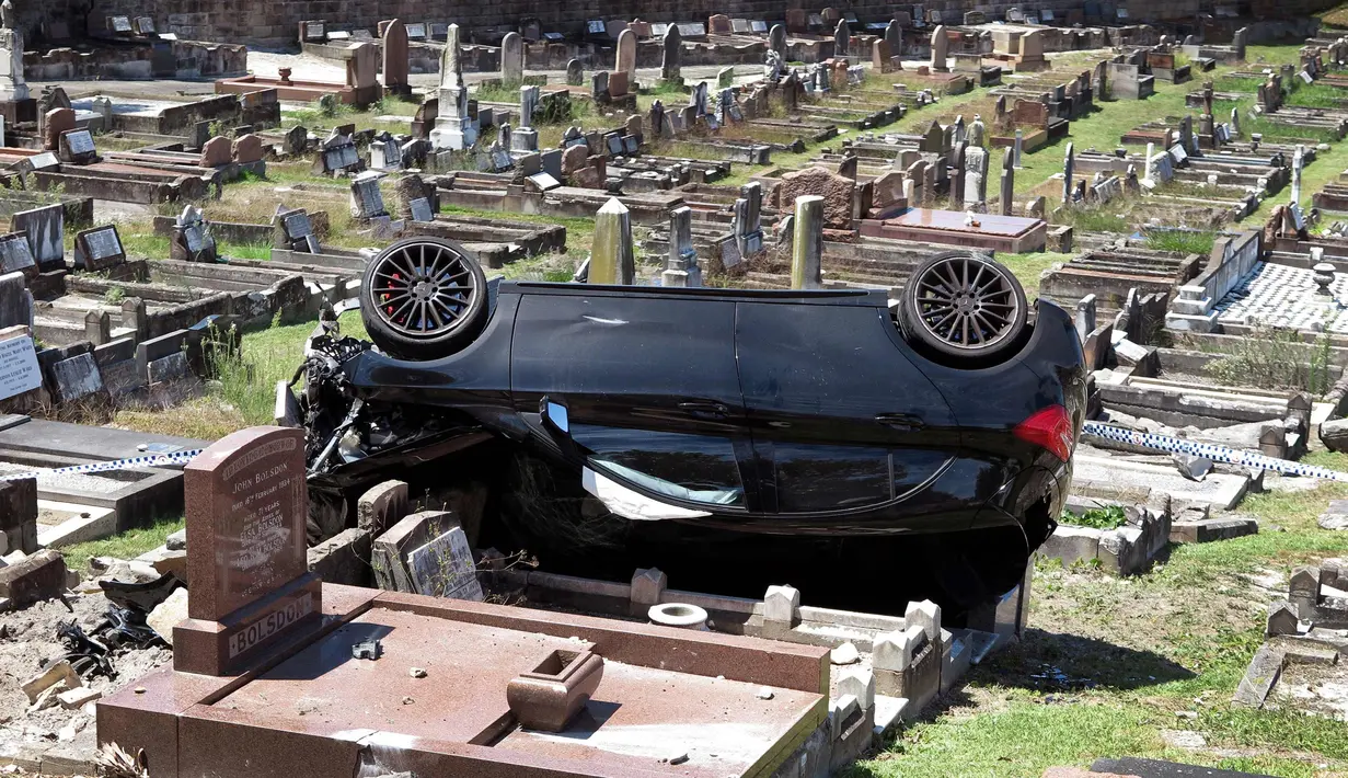 Kondisi mobil SUV Mercedes usai menabrak nisan di sebuah pemakaman di pinggiran selatan South Coogee, Australia (6/2). Kecelakaan terjadi setelah pengemudi diduga mabuk. (AFP Photo/William West)