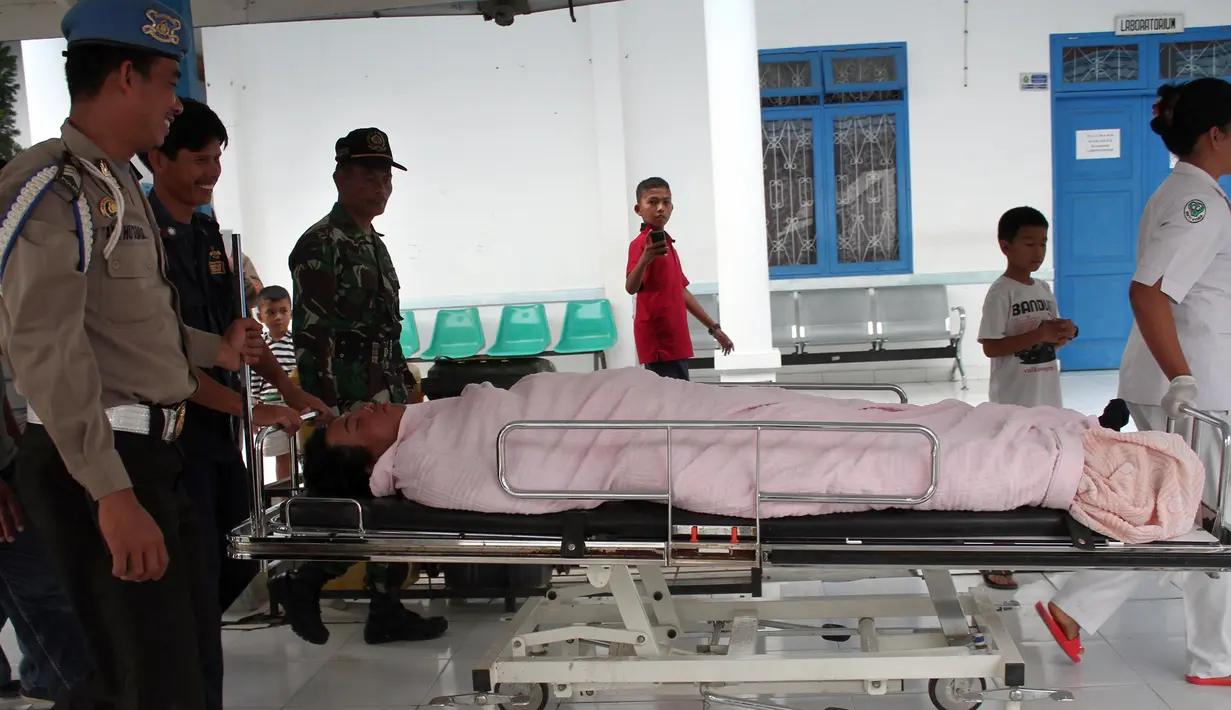 Korban helikopter EC 130  jatuh yang selamat, Fransiskus Subihardayan tiba di sebuah rumah sakit di Samosir setelah ditemukan Tim SAR mengapung di Danau Toba, Sumatera, Selasa (13/10). (AFP PHOTO/ALBERT Damanik)