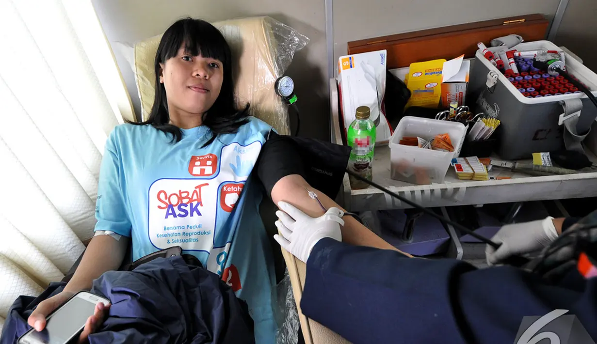 Seorang remaja putri melakukan donor darah dalam acara Dance4life di Bundaran HI, Jakarta, Minggu (7/12/2014). (Liputan6.com/Miftahul Hayat)