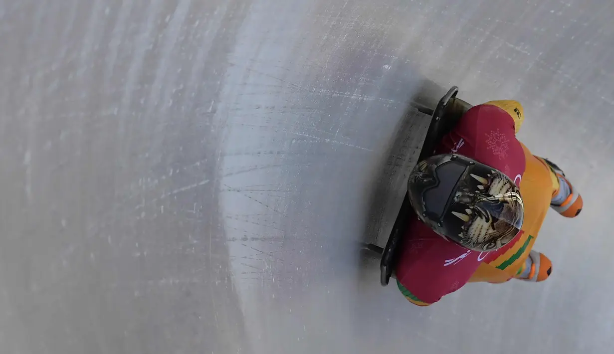 Atlet balap kereta salju, Akwasi Frimpong dari Ghana memulai sesi latihan pada Olimpiade Musim Dingin Pyeongchang 2018 di Olympic Sliding Center di Pyeongchang, Korsel (21/2). Akwasi memakai helm dengan design kepala harimau. (AFP Photo/Mohd Rasfan)