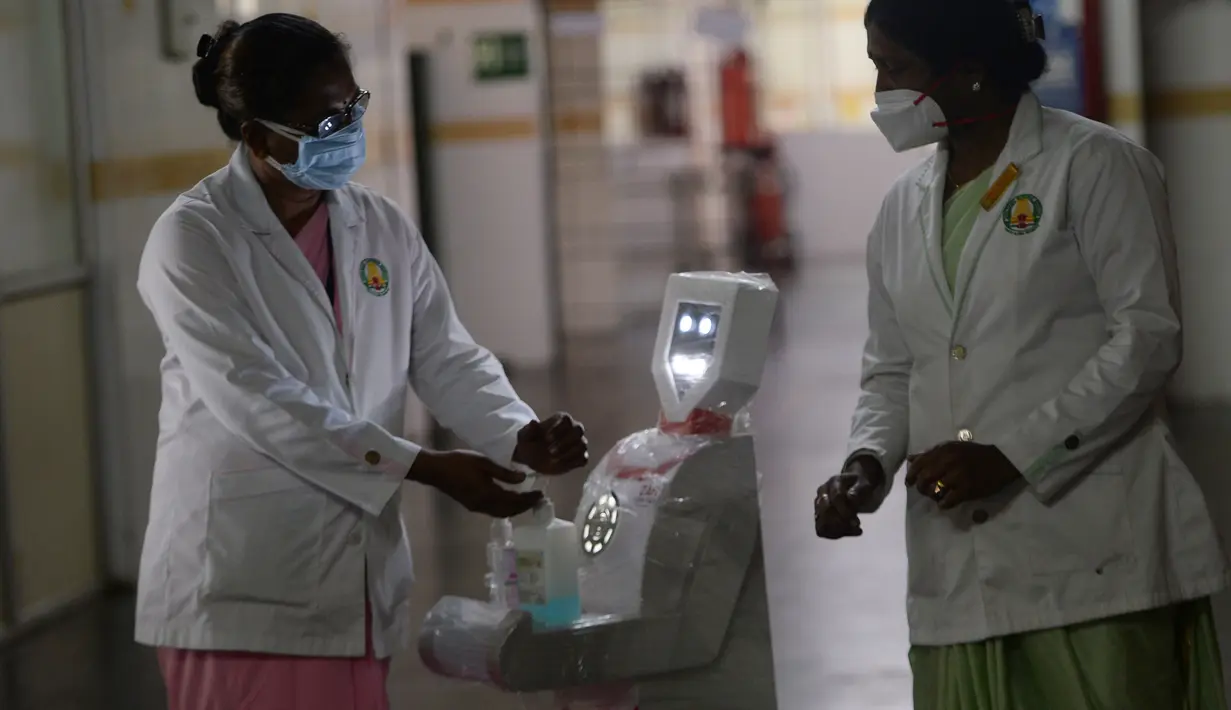 Staf medis berpartisipasi dalam demo robot interaktif 'Zafi' di rumah sakit Stanley Medical di Chennai, 6 April 2020. Rumah sakit ini mengerahkan robot untuk melayani makanan dan obat-obatan bagi pasien Covid-19 dalam upaya meminimalkan tenaga medis tertular virus corona. (Arun SANKAR/AFP)