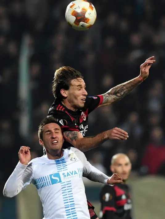 Gelandang AC Milan, Lucas Biglia, duel udara dengan gelandang Rijeka, Mario Gavranovic, pada laga Liga Europa di Stadion HNK Rijeka, Jumat (8/12/2017). AC Milan takluk 0-2 dari Rijeka. (AFP/Stringer)