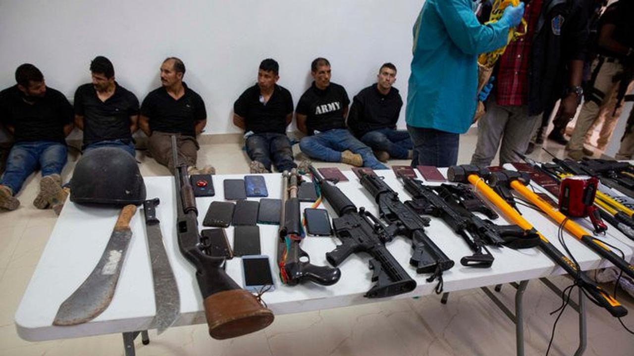 Para tersangka pembunuhan Presiden Haiti Jovenel Moise, beserta senjata dan peralatan yang diduga mereka gunakan, ditunjukkan kepada media di Port-au-Prince pada 8 Juli 2021 (AP Photo/Joseph Odelyn)