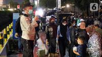 Polisi melakukan imbauan menggunakan pengeras suara terhadap warga yang berkerumun di kawasan Bundaran HI, Jakarta, Jumat (31/12/2021). Untuk mencegah penyebaran COVID-19, petugas gabungan melakukan pembubaran aktivitas warga di malam Tahun Baru. (Liputan6.com/Angga Yuniar)