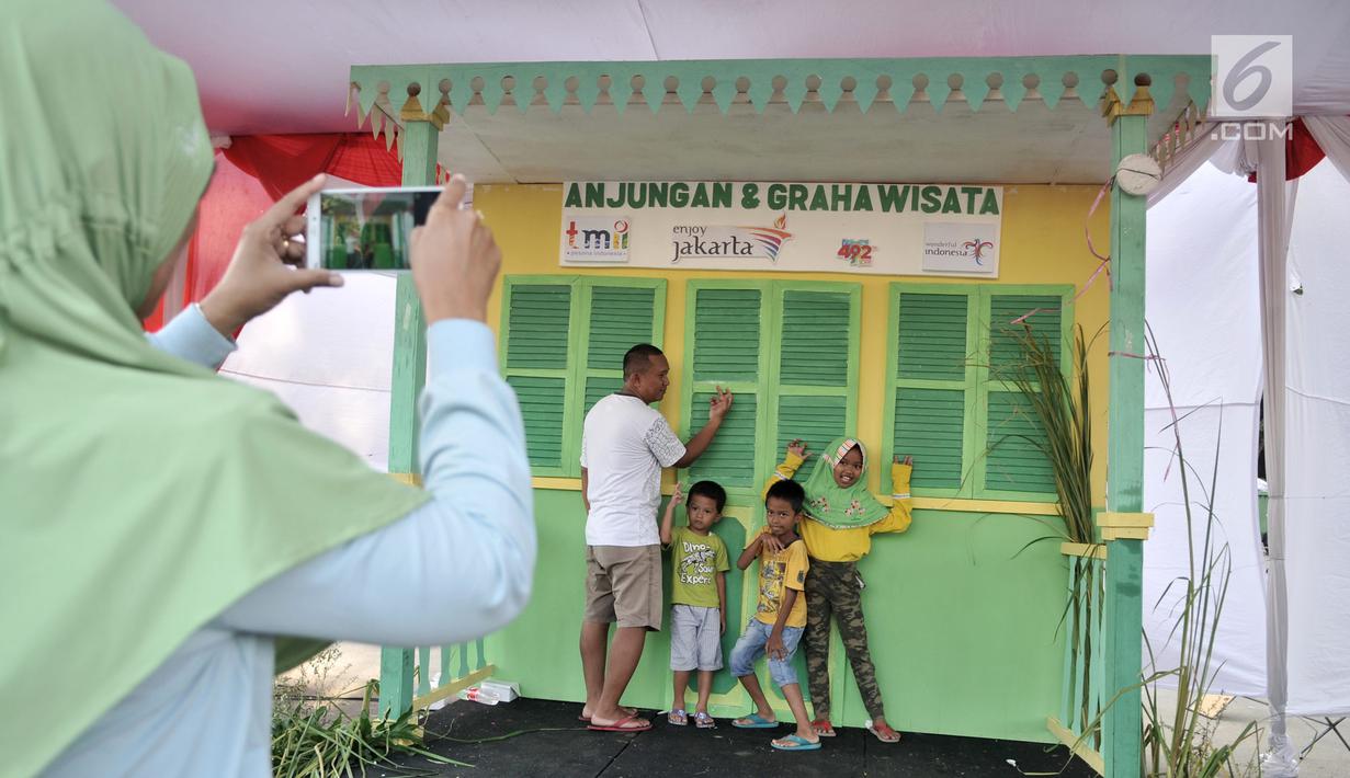 Warga saat mengunjungi salah satu rumah adat Betawi selama Lebaran Betawi 2019 di Monas, Jakarta, Minggu (21/7/2019).Untuk pertama kalinya Lebaran Betawi digelar di Monas yang diisi oleh beragam seni dan budaya masyarakat Betawi dalam rangka memeriahkan HUT DKI Jakarta.(merdeka.com/Iqbal S. Nugroho)