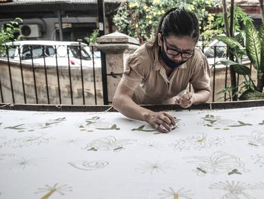 Pembatik disabilitas menyelesaikan karyanya di Rumah Batik Palbatu, Jakarta, Kamis (3/12/2020). Rumah Batik Palbatu mempercayakan kepada penyandang disabilitas binaannya untuk membuat kain batik, baik bercorak tradisional, temporer maupun perpaduan keduanya. (merdeka.com/Iqbal S. Nugroho)