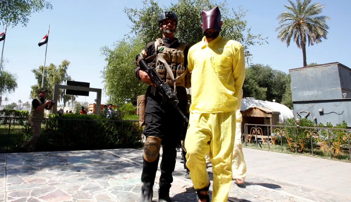 Seorang pria ditutupi wajahnya setelah ditangkap karena diduga sebagai militan ISIS saat akan konferensi pers di Irak direktorat intelijen militer di Baghdad, Irak, (7/9). Militan ISIS ditangkap hidup-hidup oleh Militer Irak. (REUTERS/Khalid al Mousily)