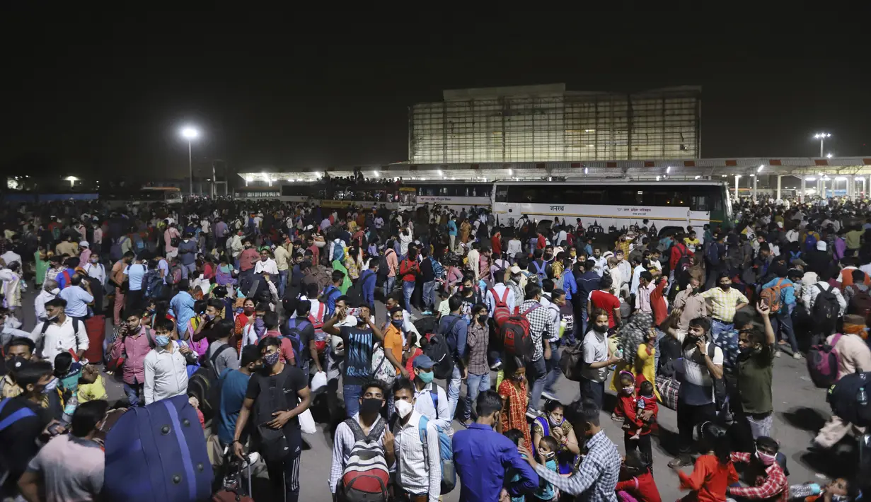 Ratusan buruh migran menunggu di terminal bus untuk berangkat ke desa mereka, New Delhi, India, Senin (19/4/2021). Pihak berwenang mengatakan pada hari Senin bahwa rumah sakit telah didorong hingga batasnya. (AP Photo)