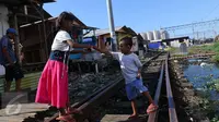Anak-anak bermain di jalur kereta api di premukiman kampung bandan, Jakarta, Jumat (15/7). Nantinya masing-masing US$ 216,5 juta atau sekitar 2,8 triliun rupiah untuk perbaikan infrastruktur permukiman kumuh di Indonesia. (Liputan6.com/Angga Yuniar)