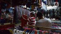Warga memilih pakaian bekas (Thrifting) di pasar Proyek Senen, Jakarta, Selasa (12/10/2021). Akibat pandemi membuat tren thrifting menjadi alternatif pemasukan baru bagi para pedagang pakaian bekas di tengah pandemi. (merdeka.com/Imam Buhori)