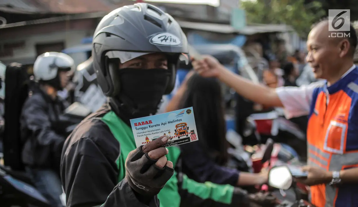 Pengendara menunjukkan stiker saat petugas PT KAI Daop I menggelar sosialisasi tertib berlalu lintas di pintu perlintasan sebidang kawasan Bukit Duri, Jakarta, Selasa (17/9/2019). Sosialisasi dilakukan karena banyaknya kecelakaan akibat ketidakdisiplinan pengendara. (Liputan6.com/Faizal Fanani)