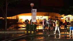 Petugas pemadam kebakaran mencoba memadamkan api di sebuah mal sesaat setelah gempa bumi bermagnitudo 6,4  melanda General Santos City, di pulau selatan Mindanao, Kamis (16/10/2019). Sekitar 100 anggota damkar dikerahkan untuk memadamkan api yang diduga akibat kebocoran gas. (EDWIN ESPEJO / AFP)