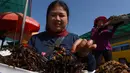 Pedagang Kamboja menyiapkan tarantula goreng untuk dijual di wilayah Skun, Provinsi Kampong Cham, 4 Desember 2019. Daerah yang kerap dijuluki "Spiderville" tersebut menjadi tempat menarik bagi para turis berburu aping, camilan tradisional dari tarantula ini. (TANG CHHIN Sothy / AFP)