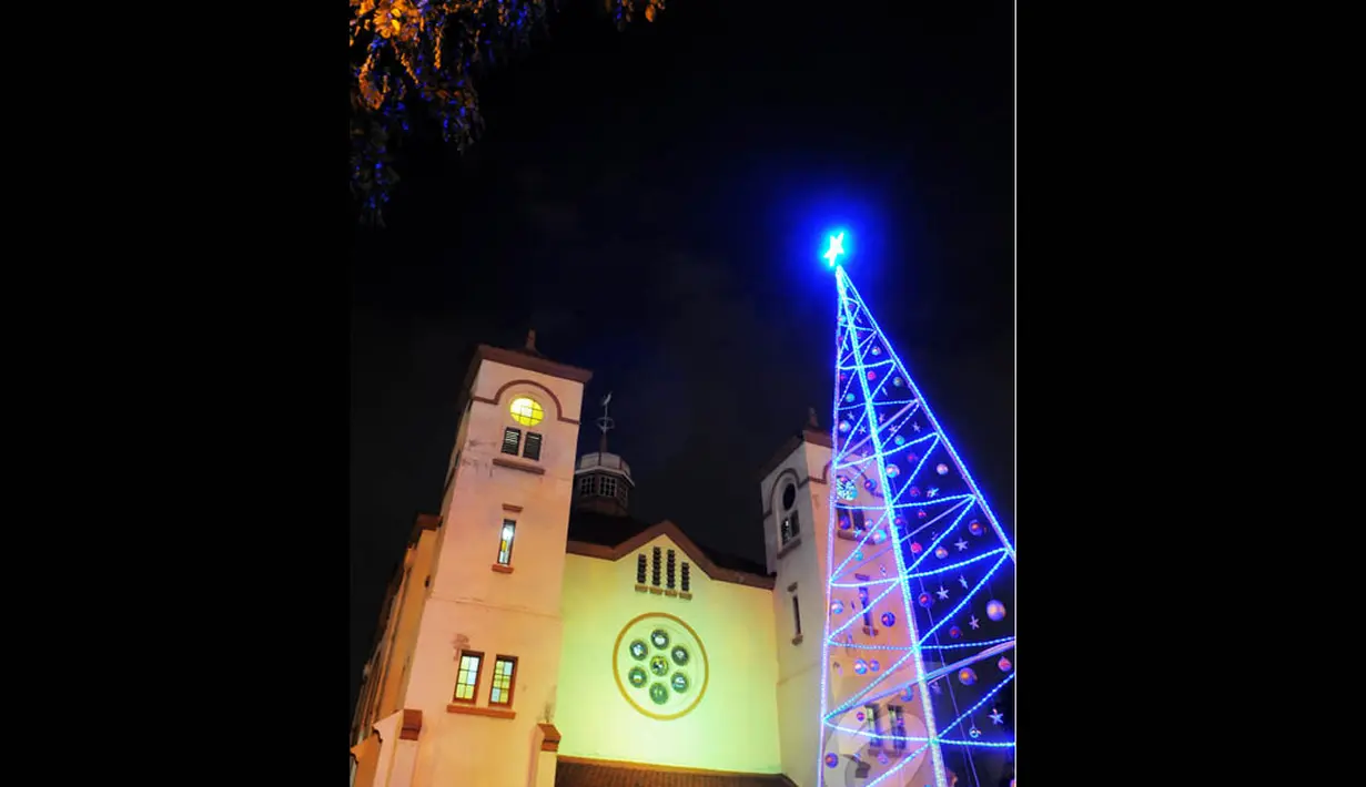 Pohon Natal yang terbuat dari pipa besi serta dihiasi bola bola dan lampu berwarna warni terpasang di depan Gereja "Ayam" GPIB Pniel, Jakarta, Rabu (24/12/2014). (Liputan6.com/Faisal R Syam)