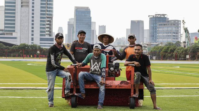 Para pekerja foto bersama di Lapangan Aldiron. (Bola.com/M. Iqbal Ichsan)