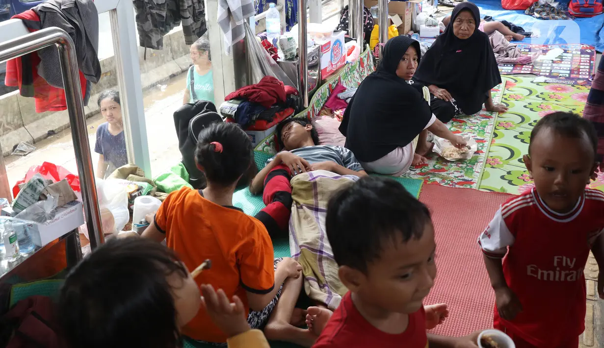 Warga korban banjir mengungsi di Halte Transjakarta Jembatan Baru, Cengkareng, Jakarta, Jumat (3/1/2020). Lansia dan anak-anak ikut mengungsi di Halte Transjakarta Jembatan Baru karena rumah mereka masih terendam banjir. (Liputan6.com/Angga Yuniar)