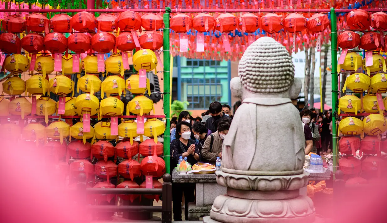 <p>Para jemaah berdoa setelah kebaktian untuk merayakan ulang tahun Buddha di Kuil Jogye, Seoul, Korea Selatan, Minggu (8/5/2022). (ANTHONY WALLACE/AFP)</p>