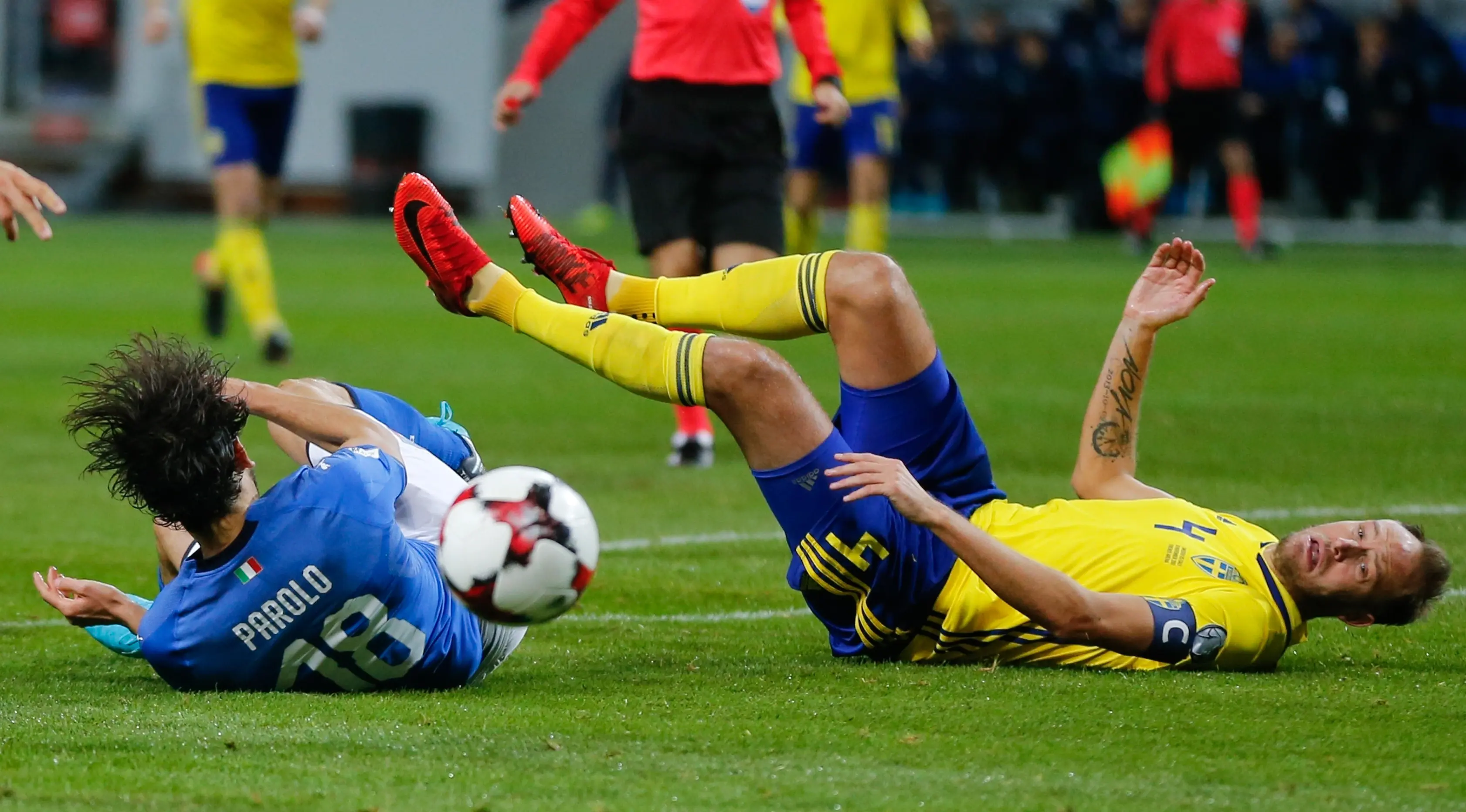 Pemain Italia Marco Parolo (kiri) dan pemain Swedia Andreas Granqvist terjatuh saat berebut bola dalam pertandingan Kualifikasi Piala Dunia 2018 di Stadion Friends Arena, Solna (10/11). (AP Photo/Frank Augstein)