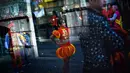Seorang anak mengenakan pakaian tradisional China saat perayaan menjelang tahun baru China di Lisbon, Portugal (21/1). Perayaan tahun baru Imlek merupakan salah satu hari besar yang dirayakan oleh kaum Tionghoa. (AFP/Patricia De Melo Moreira)