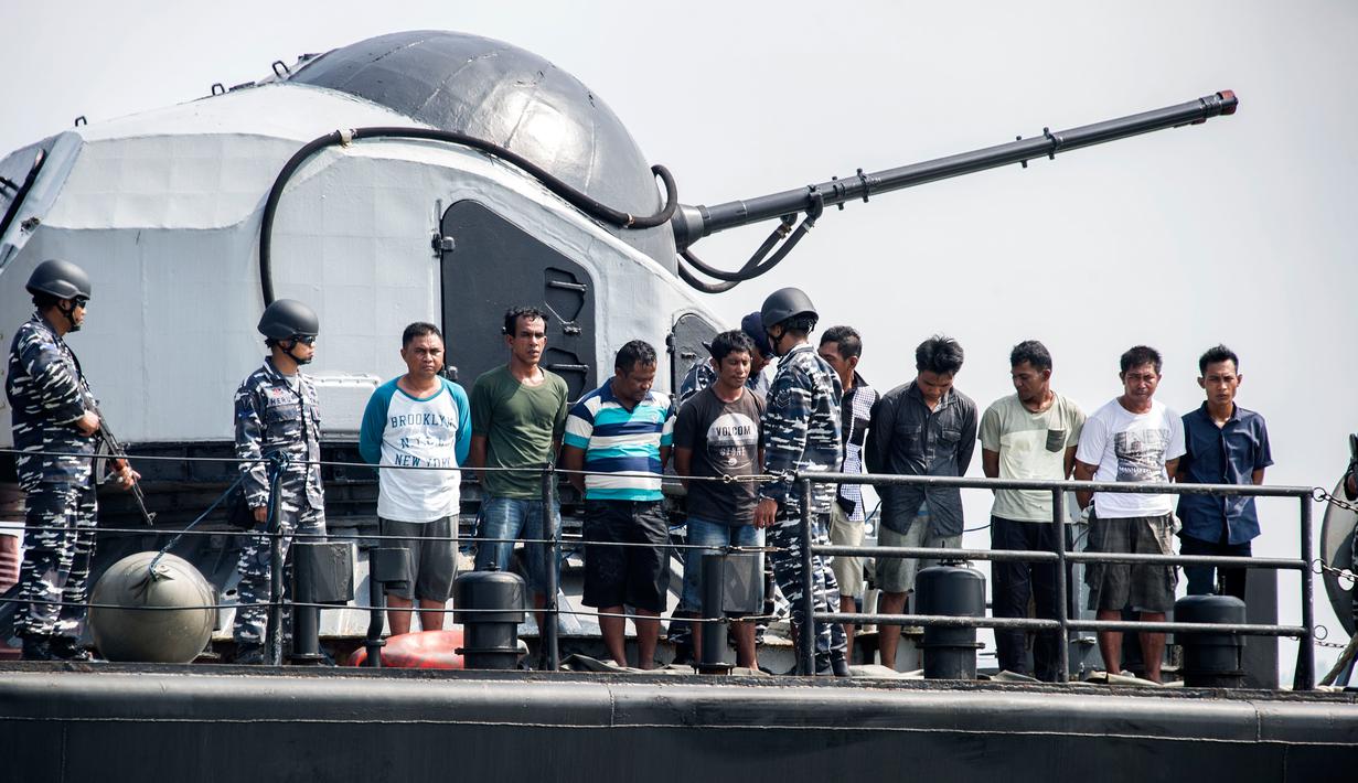 Sembilan Tersangka perompak dihadirkan oleh Anggota TNI AL di Surabaya, Jawa Timur, (10/5). Sembilan tersangka diduga melakukan pembajakan terhadap kapal tanker berbendera Singapura di perairan Tanjung Puting, Kalimantan. (AFP PHOTO/JUNI KRISWANTO)