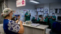 Perawat Chile, Damaris Silva memainkan biola untuk pasien COVID-19 di Unit Perawatan Intensif rumah sakit El Pino di Santiago pada 9 Juli 2020. Silva melakukan ini untuk memberikan cinta, keyakinan, harapan dan semangat kepada pasien dan perawat yang sedang bertugas. (Martin BERNETTI / AFP)