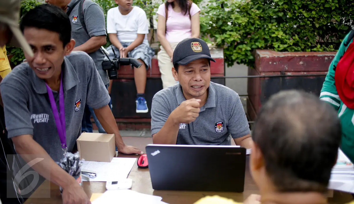 Petugas memberikan penjelasan kepada warga yang mendaftarkan namanya di posko KPUD DKI di kawasan Bundaran HI, Jakarta, Minggu (26/3). KPUD membuka posko pemeriksaan data pemilih terdaftar untuk Pilkada DKI 2017 putaran kedua. (Liputan6.com/Faizal Fanani)