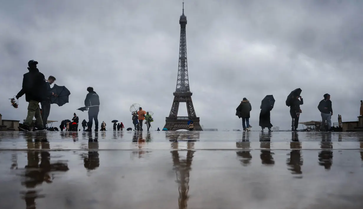 <p>Pengunjung berjalan di Esplanade du Trocadero dengan latar belakang Menara Eiffel, yang ditutup untuk umum pada hari keempat pemogokan stafnya, di Paris pada 22 Februari 2024. (Dimitar DILKOFF/AFP)</p>