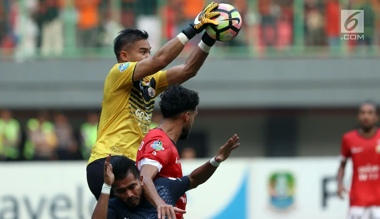Penjaga gawang Persija, Andritany berjibaku menangkap bola saat laga melawan PSM Makassar pada lanjutan Liga 1 Indonesia di Stadion Patriot Candrabhaga, Bekasi, Selasa (15/8). Laga berakhir imbang 2-2. (Liputan6.com/Helmi Fithriansyah)