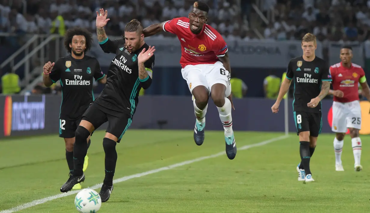 Gelandang Manchester United, Paul Pogba, berebut bola dengan bek Real Madrid, Sergio Ramos, pada laga Piala Super Eropa di Stadion Philip II, Skopje, Selasa (8/8/2017). Real Madrid menang 2-1 atas Manchester United. (AFP/Armend Nimani)