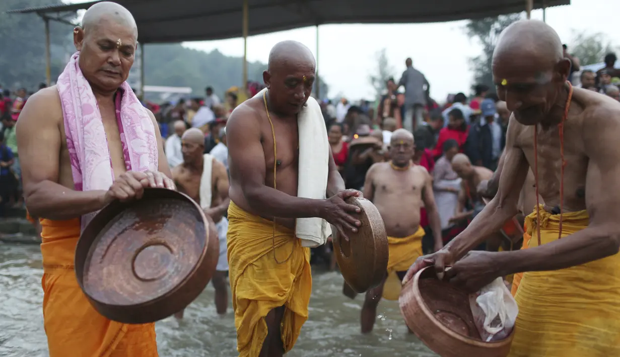 Umat Hindu Nepal mencuci peralatan untuk melakukan ritual selama festival Kuse Aunsi di Kathmandu, Jumat (30/8/2019). Anak laki-laki dan perempuan yang ayahnya masih hidup wajib menghabiskan waktu bersama dengan membawa hadiah. (AP Photo/Niranjan Shrestha)