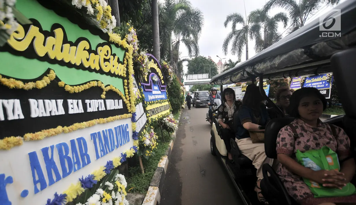 Pelayat melintasi karangan bunga duka cita untuk mendiang Eka Tjipta Widjaja di depan Rumah Duka Sentosa RSPAD Gatot Soebroto, Jakarta, Minggu (27/1). Eka Tjipta Widjaja meninggal dunia pada usia 98 tahun. (Merdeka.com/Iqbal Nugroho)